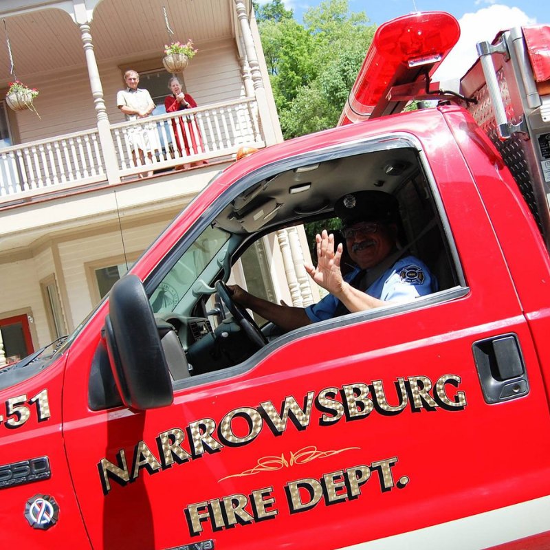 A firefighter waves from a Narrowsburg Fire Department truck.